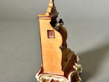 a small figurine of a man sitting on top of a tower
