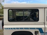 a white truck with blue stripes parked on the side of the road