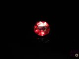 an image of a red light shines on a black surface