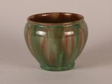 a green and red vase sitting on a white surface