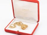 an image of a gold necklace in a red box on a white surface