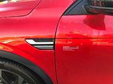 a close up of a red car door with a sticker on it