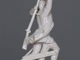 a statue of a man holding a sword on a table