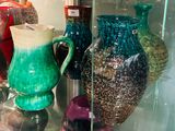 de nombreux vases de différentes couleurs exposés dans une vitrine