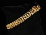 a close up of a gold bracelet on a black pillow