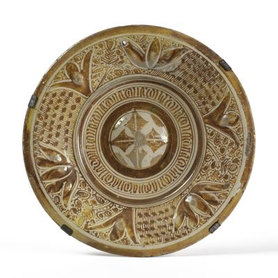 une assiette marron ornée de motifs sur un fond blanc