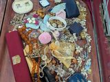 une valise remplie de bijoux et d'autres objets, posée par terre