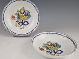 pair of blue and white plates with flowers on them on a table