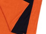 L'écharpe orange et noire est pliée sur la couverture noire et orange.
