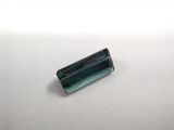 a close up of a green tourmaline stone on a white surface