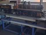 a model train sitting on a workbench in a garage