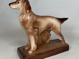une figurine représentant un chien debout sur un socle