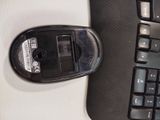 a computer mouse sitting next to a keyboard on a desk