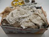 a box full of laces on a table next to a plate of food