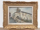 painting of a building in a gold frame on a table