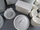a lot of white plates and bowls on the table