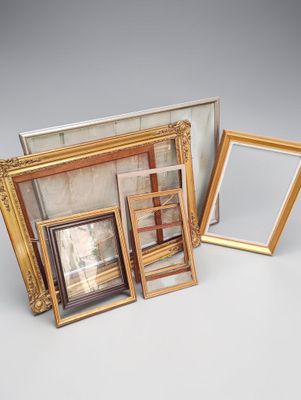 three different sized picture frames sitting next to each other on a table