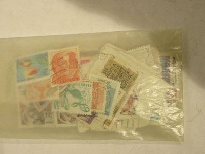 beaucoup de timbres dans un sachet en plastique posé sur une table