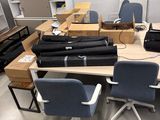 a room with several chairs and a table with a laptop on it