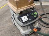 une machine posée au sol, sur laquelle se trouve une boîte