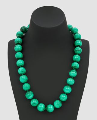 un collier de perles vertes sur un mannequin noir