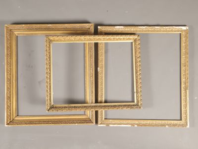 trois cadres dorés sur un mur gris, avec un fond blanc