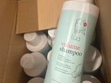 une bouteille de shampoing posée dans une boîte en carton