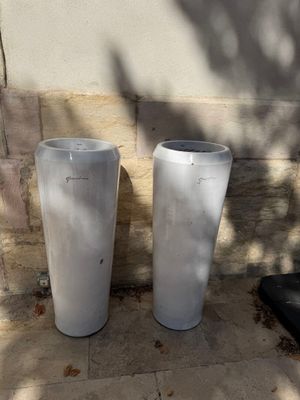 deux vases blancs posés l'un à côté de l'autre par terre