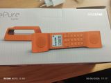 un téléphone portable orange posé sur une boîte, sur une table