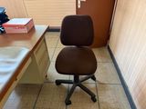 a brown office chair sitting in front of a desk