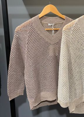 deux pulls suspendus à un cintre dans un magasin de vêtements