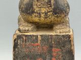 an old statue of a man sitting on top of a stone block