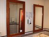 une salle de bains équipée d'un lavabo, d'un miroir et d'un distributeur de papier toilette