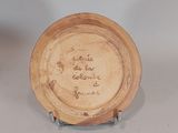 a small plate with writing on it sitting on a table