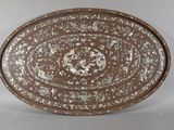 a brown plate with silver designs on it