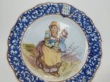 a blue and white plate with a picture of a woman on it