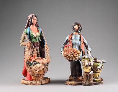 deux figurines représentant un homme et une femme portant des paniers remplis de nourriture