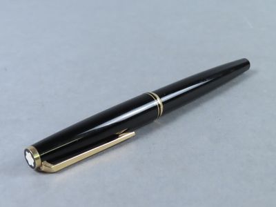 a close up of a pen on a table with a white background