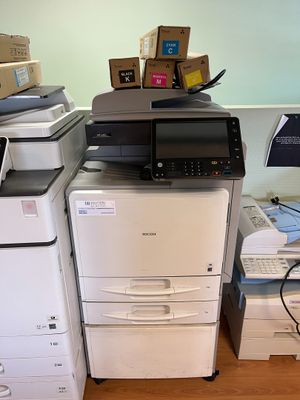 a stack of office printers and a printer on the floor