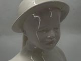 a white statue of a child with a hat on