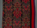 a red, black and yellow scarf with a design on it