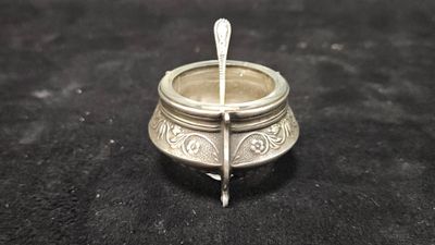 a small silver bowl with a spoon sticking out of it