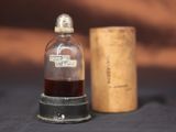 une petite bouteille de vin à côté d'un bouchon en liège