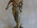 statue en bronze représentant un garçon muni d'un arc et de flèches, posée sur un socle