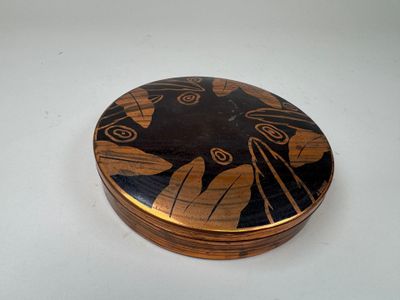 une boîte en bois ornée d'un motif noir et or