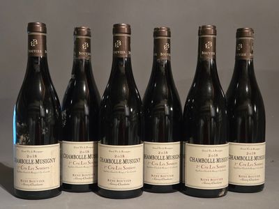 six bouteilles de vin sont alignées sur une table