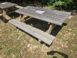 a picnic table with a sign on it in the grass