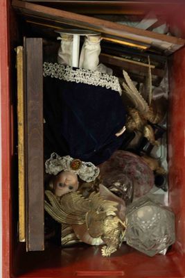 a small red box with a doll inside of it
