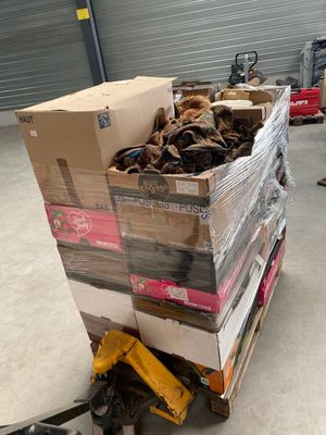 Des cartons de chaussures sont empilés sur une palette dans un entrepôt