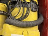 un aspirateur jaune et une valise rouge sur une étagère